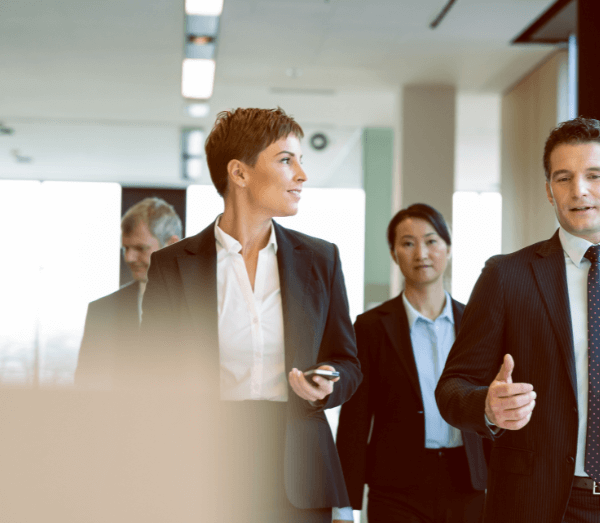 Nos-consultants 4 hommes et femmes d'affaires dans un hall au travail en train de marcher